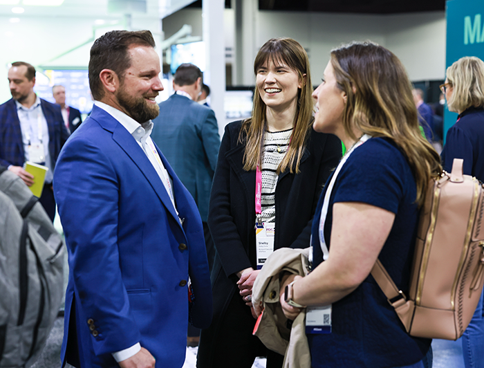three conference attendees networking in the exhibit hall