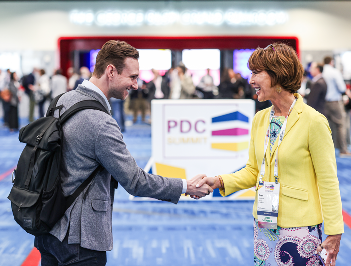two conference attendees shaking hands